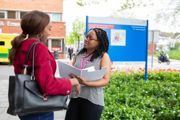 Two women talking outside a hospital